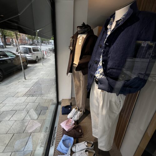 Zwei Schaufensterpuppen tragen elegante Herbstmode in Blau und Beige mit Accessoires